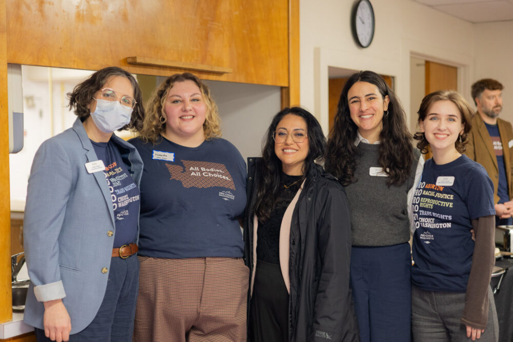 A group of Pro-Choice Washington activists is business attire stand with Senator Yazmin Trudeau