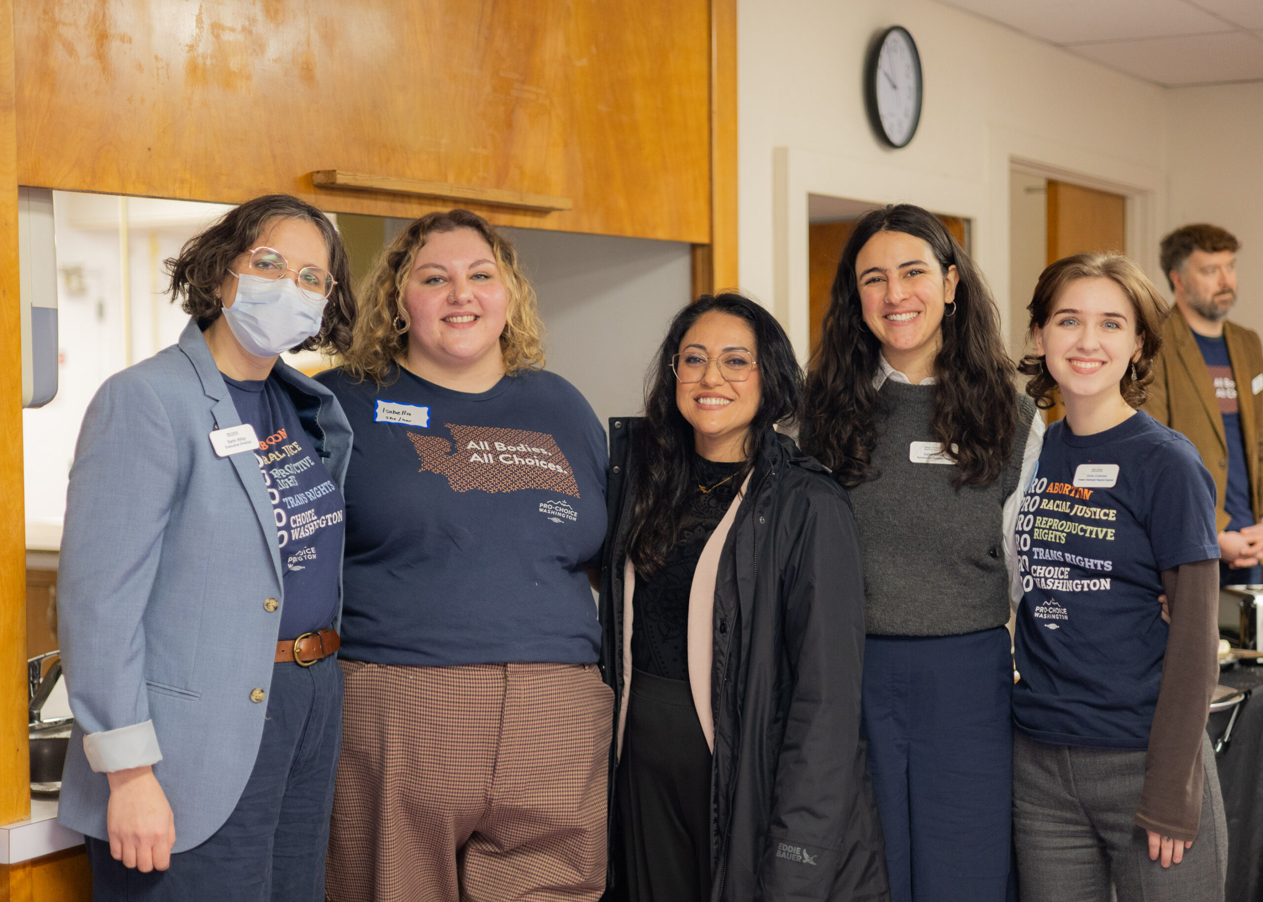 A group of Pro-Choice Washington activists is business attire stand with Senator Yazmin Trudeau