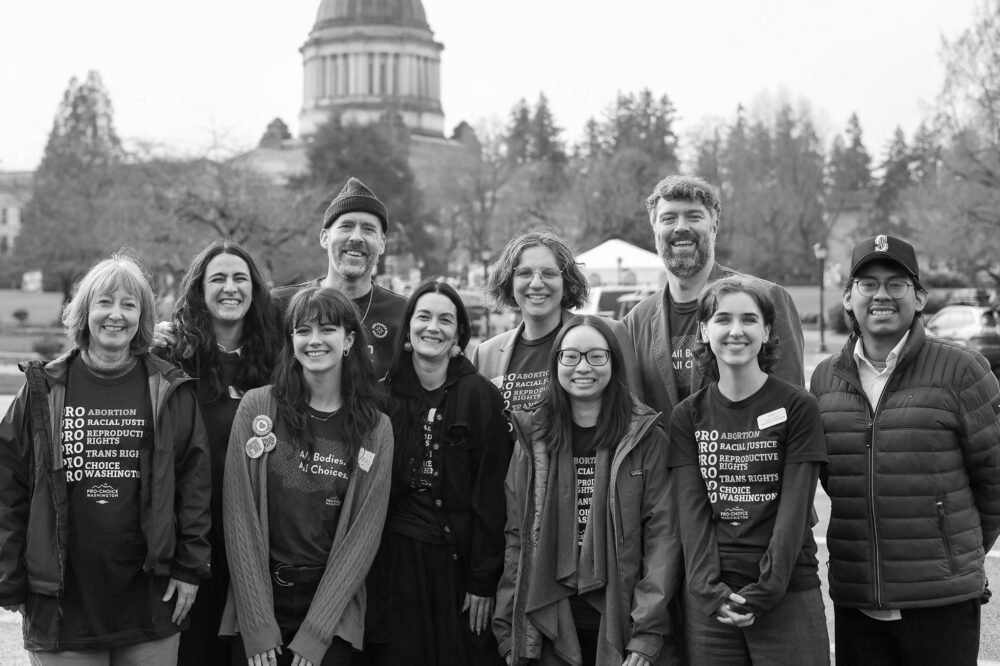 Members of the Northwest Reproductive Equity Action Team standing in front of the Washington State Capitol building